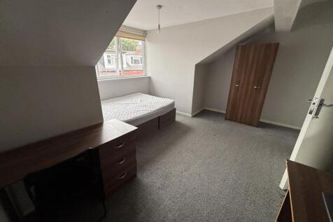 A tidy and well-lit single bedroom with a windo...