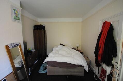 A cozy double bedroom with a neatly made bed, a...