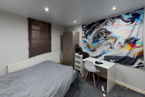 A well-lit bedroom featuring a comfortable doub...