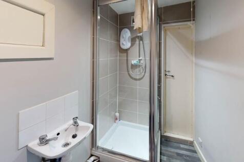 A modern, clean bathroom with a shower unit and...
