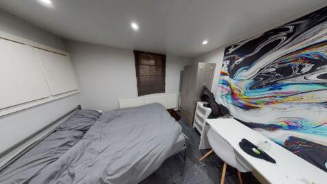 A tidy and functional bedroom featuring a comfo...