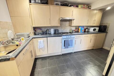 Bright fitted kitchen with light wood cabinets,...