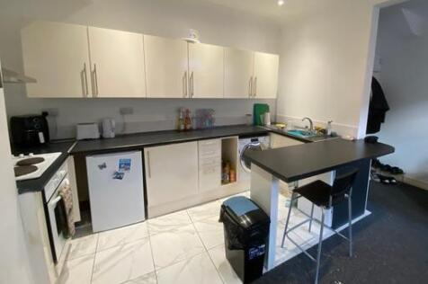 A modern, bright kitchen area featuring white c...