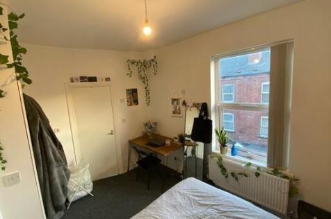 A cozy bedroom with a large window allowing nat...