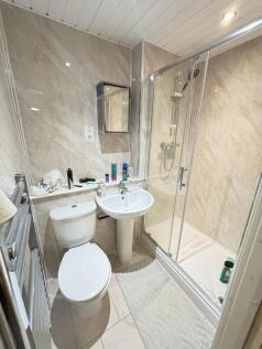 Modern bathroom featuring a spacious shower enc...