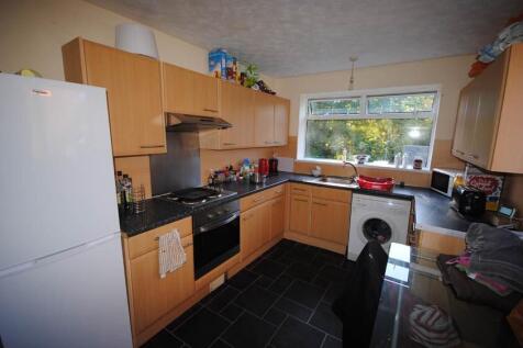 A well-lit kitchen featuring wooden cabinetry, ...