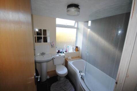 A clean and functional bathroom with a bathtub,...