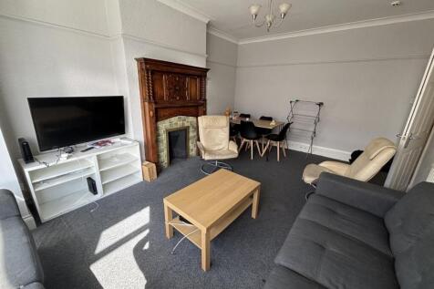 A spacious and well-lit living room featuring c...