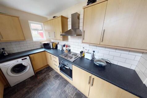 A modern kitchen featuring wooden cabinetry, a ...