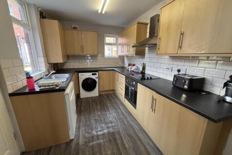 A modern kitchen with ample cabinet space, a wa...