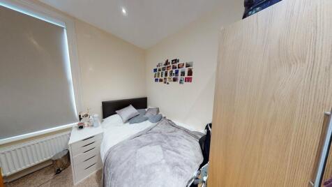 A cozy bedroom featuring a double bed with neat...