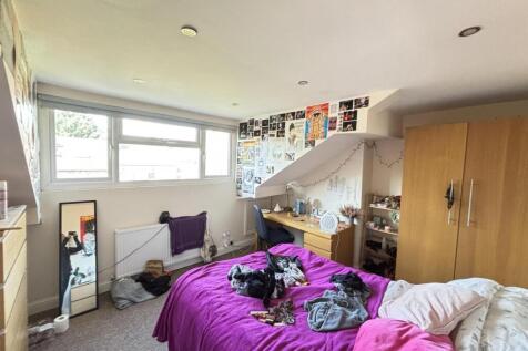 A spacious and well-lit master bedroom featurin...