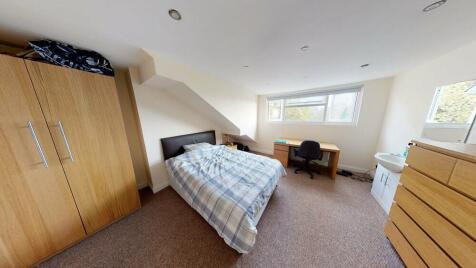 A spacious, well-lit master bedroom featuring a...