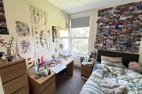 A spacious and well-lit bedroom featuring a lar...