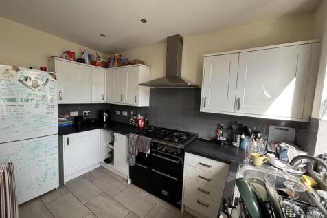 A modern kitchen with white cabinets, a black c...