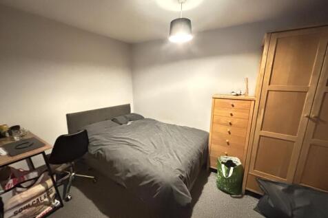 A cozy bedroom featuring a large bed with a stu...