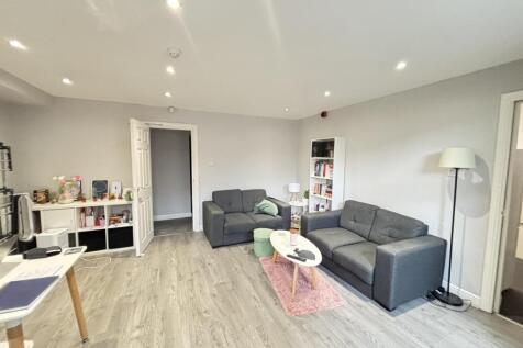 A spacious and modern living room featuring com...