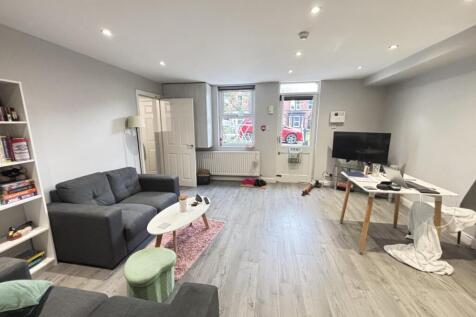 A bright and spacious living room with large wi...