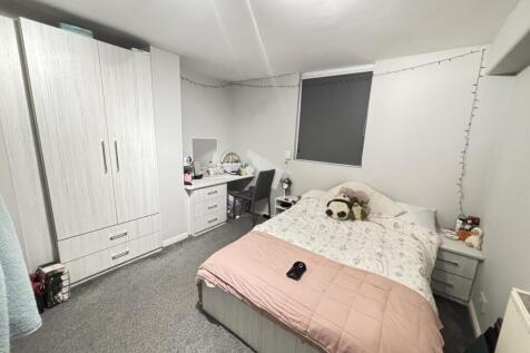 A bright and tidy bedroom featuring a large bed...