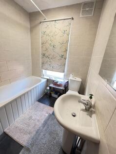 A well-maintained bathroom featuring a bathtub,...