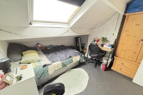 A cozy bedroom featuring a bed with a pillow an...