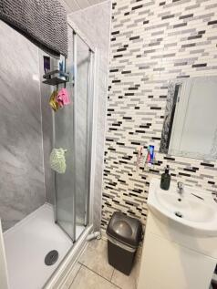 A clean, modern bathroom featuring a shower enc...