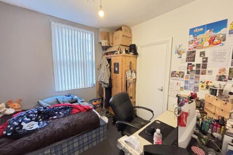 A cozy bedroom featuring a single bed with colo...