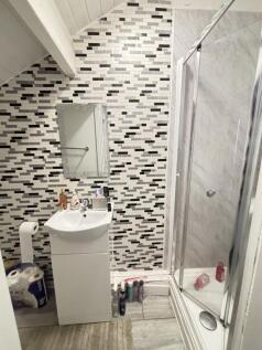 A compact but tidy bathroom with a shower enclo...