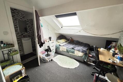 A cozy bedroom with a single bed positioned ben...