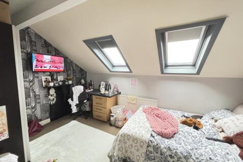 A bright and cozy bedroom featuring two neatly ...