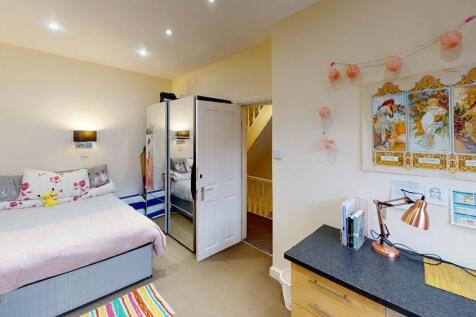 A bright and welcoming bedroom featuring a comf...