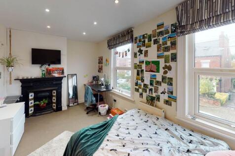 A bright and welcoming bedroom with a large win...