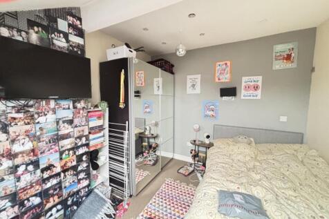 A cozy student bedroom featuring a comfortable ...