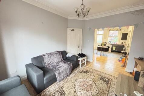 A spacious and welcoming living room with a lar...