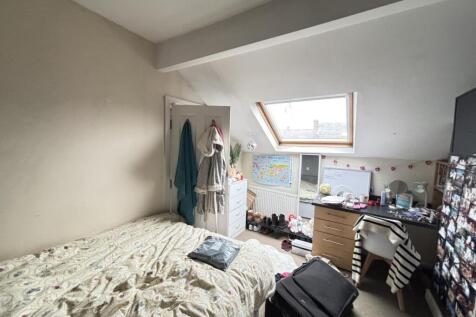 A cozy bedroom featuring a comfy bed, a skyligh...