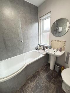 A modern bathroom featuring a bathtub with a sh...