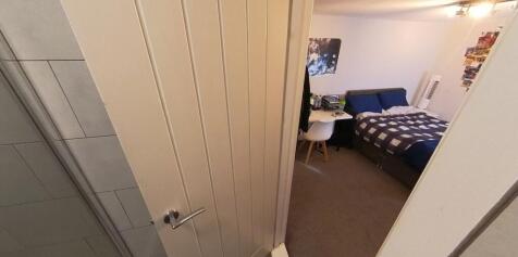 A cozy student bedroom featuring a single bed, ...