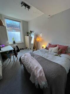 A cozy and welcoming master bedroom featuring a...