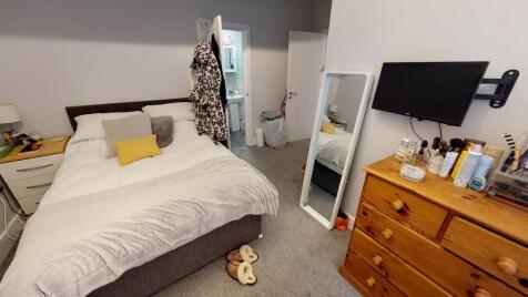 A cozy bedroom featuring a large bed with a com...