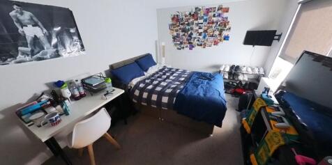 A cozy bedroom featuring a single bed, a study ...