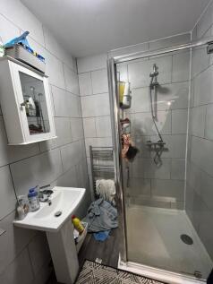 A modern bathroom suite featuring a walk-in sho...