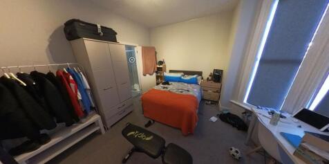 A cozy single bedroom featuring a neatly made b...