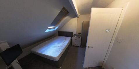 A compact bathroom featuring a toilet and minim...