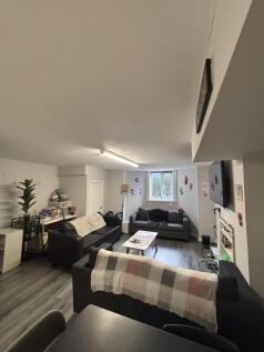 A spacious and well-lit living room with large ...