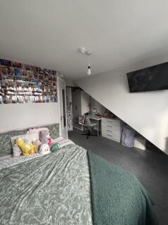 Comfortable bedroom featuring a large bed, cozy...