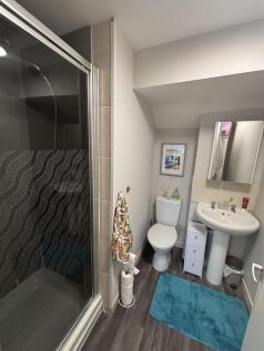 A modern, clean bathroom featuring a shower enc...