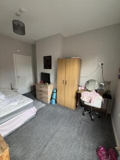 A cozy single bedroom featuring a bed, a wardro...