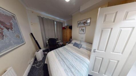 A bright and tidy bedroom featuring a double be...