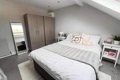 A bright and spacious master bedroom featuring ...