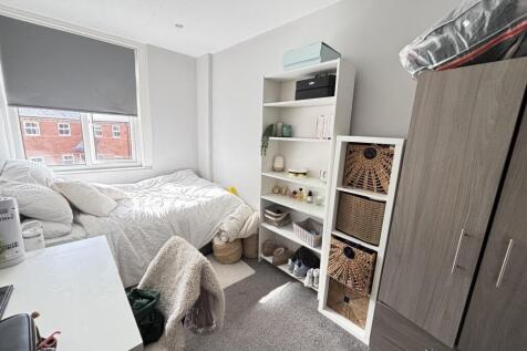A bright and tidy bedroom with a comfortable be...